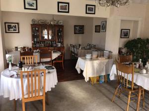 un comedor con mesas con manteles blancos en Lisnagalt Lodge, en Coleraine