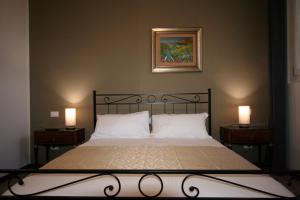 een slaapkamer met een bed met 2 lampen en een foto bij SanSiroFiera in Milaan