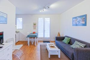 ein Wohnzimmer mit einem Sofa und einem Tisch in der Unterkunft Appart'Hôtel Bellevue in Bayonne