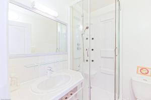 Un baño blanco con lavabo y ducha. en Appart'Hôtel Bellevue, en Bayona 33 fotos más