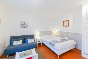 1 dormitorio con 2 camas y sofá azul en Appart'Hôtel Bellevue, en Bayona