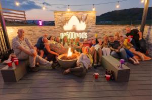 a group of people sitting around a fire pit at North Coast 500 Pods in Achmelvich