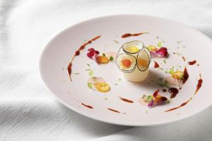 a plate of food with a drink on a table at Relais & Châteaux La Maison Des Têtes in Colmar