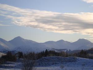 a snow covered mountain range with mountains in the background at Posh Pod in Tyndrum