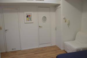 ein Wohnzimmer mit weißen Schränken und einer weißen Couch in der Unterkunft Top Studio Marolles in Brüssel