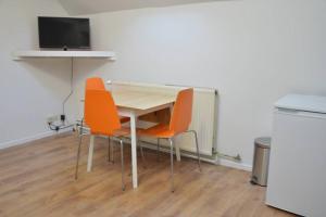 - une table avec deux chaises et une télévision dans la chambre dans l'établissement Top Studio Marolles, à Bruxelles