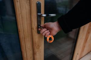 a hand unlocking a door with a pumpkin key at North Coast 500 Pods in Achmelvich