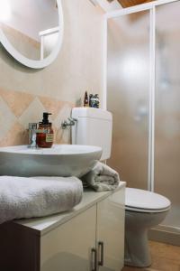 bagno con lavandino, servizi igienici e specchio di B&B Anthea a Linguaglossa