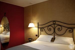 Habitación de hotel con cama y lámpara en Locanda Viridarium en Arqua Petrarca