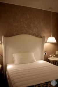 1 dormitorio con 1 cama blanca y 1 lámpara en Locanda Viridarium en Arqua Petrarca