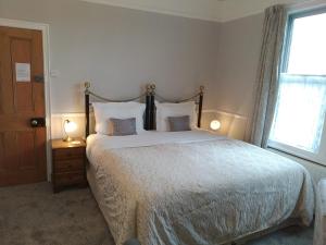 um quarto com uma cama grande e uma janela em Anton Guest House Bed and Breakfast em Shrewsbury