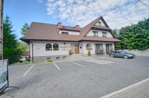 a building with a car parked in a parking lot at Willa Amaretto in Wisła