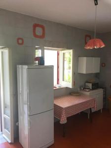 貝爾韋代雷的住宿－Villa Sasà，厨房配有桌子和白色冰箱。