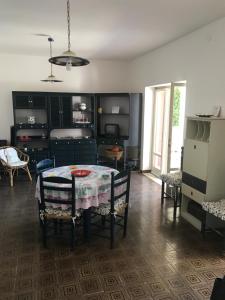 Habitación con mesa, sillas y cocina. en Villa Sasà, en Belvedere Marittimo