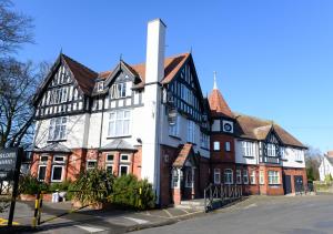 a large white and black building on a street at Miller & Carter Aughton by Innkeeper's Collection in Ormskirk
