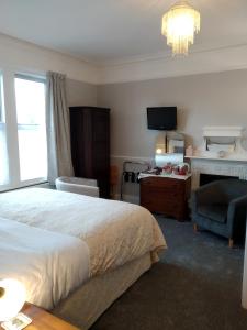 um quarto com uma cama, uma cadeira e uma televisão em Anton Guest House Bed and Breakfast em Shrewsbury