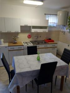 a kitchen with a table and chairs in a kitchen at Anita studio 3 Apartment in Mali Lošinj