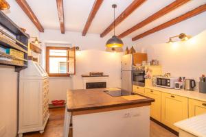 eine Küche mit gelben Schränken und einem weißen Kühlschrank in der Unterkunft Casa Santa Croce in Alà dei Sardi
