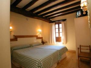 - une chambre avec un lit dans une pièce dotée d'une fenêtre dans l'établissement Hostería La Antigua, à Potes