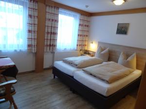 1 dormitorio con 1 cama en una habitación con ventanas en Hotel Peter, en Saalbach Hinterglemm