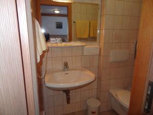 a bathroom with a sink and a toilet and a mirror at Hotel Peter in Saalbach-Hinterglemm