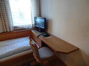 a desk with a computer on it in a room at Hotel Peter in Saalbach-Hinterglemm