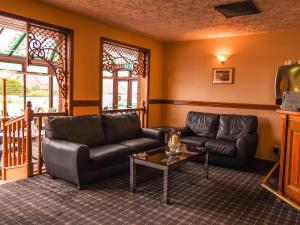
a living room with a couch, coffee table and chairs at Findlay's Hotel in Fraserburgh
