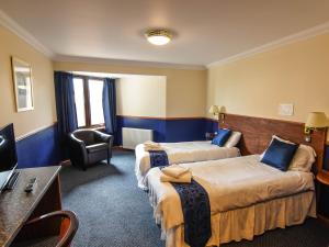 
a hotel room with two beds and a television at Findlay's Hotel in Fraserburgh
