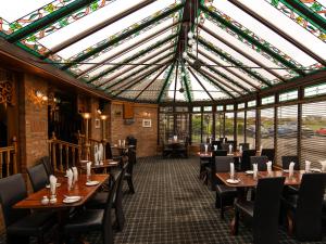 a restaurant with tables and chairs and a glass ceiling at Findlay's in Fraserburgh