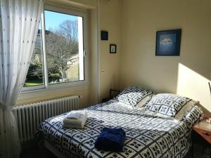 um quarto com uma cama e uma janela em Aigue Marine et Coquelicot em Jonzac