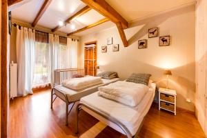twee bedden in een kamer met houten vloeren bij cosy holiday home with sauna near river in La-Roche-en-Ardenne