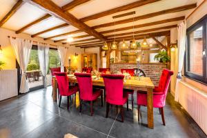 een eetkamer met een houten tafel en rode stoelen bij cosy holiday home with sauna near river in La-Roche-en-Ardenne