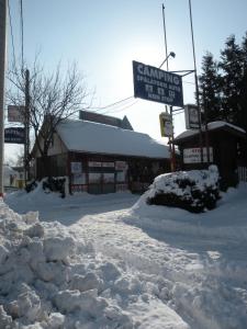 a street covered in snow next to a building at Camping Paradisul Soferilor in Onești