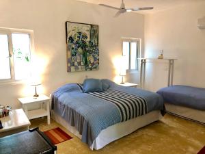 a bedroom with a bed and a painting on the wall at Junto al Rio Bungalows & Suites in Sayulita