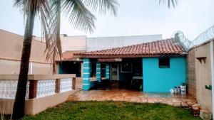 a blue house with a palm tree in front of it at Casa de Brotas in Brotas