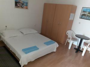 a bedroom with a bed and a table and chairs at Apartman Roko in Novalja