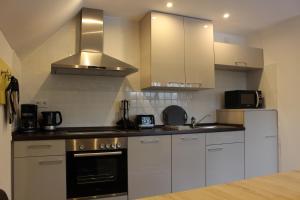 a kitchen with white cabinets and stainless steel appliances at Ferienhaus am Ruhberg in Winterberg