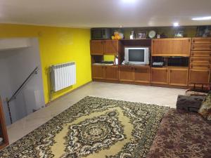 a living room with yellow walls and a rug at Хостел Мансардная комната с невысоким потолком до 170 см in Truskavets