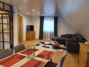 a living room with a table and a couch at Ferienwohnung Steiner 2 in Homburg +18 photos