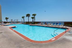 a swimming pool at a resort with people sitting in chairs at Sunrise Beach Resort IV in Panama City Beach