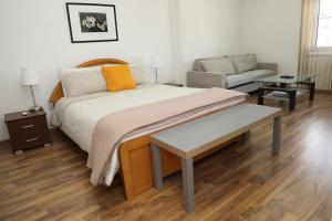 a bedroom with a large bed and a couch at Achillion Apartments By 'Flats Nicosia' in Nicosia