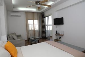 1 dormitorio con 1 cama y ventilador de techo en Achillion Apartments By 'Flats Nicosia' en Nicosia
