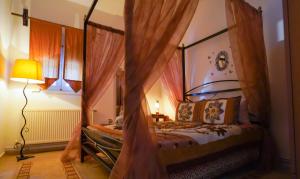 a bedroom with a canopy bed with curtains and a lamp at Guesthouse Aelia in Kato Loutraki
