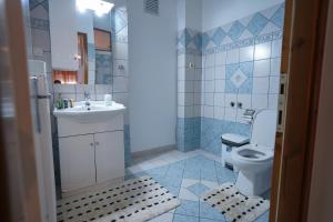 a bathroom with a white toilet and a sink at Guesthouse Aelia in Kato Loutraki
