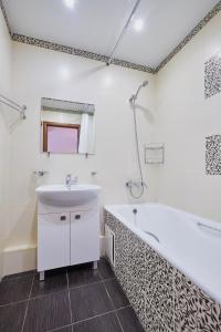 a bathroom with a white tub and a sink at ОК! Советская, 69 №7 in Tomsk