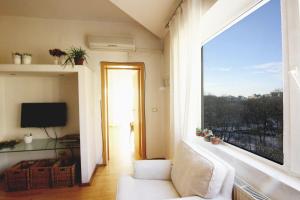 a living room with a couch and a large window at Park View Bucharest in Bucharest
