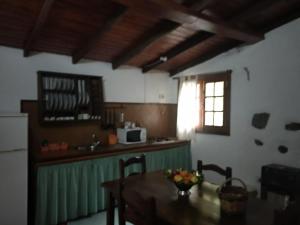 cocina con mesa y cocina con ventana en Casa Rural Higuera Morales, en Mocanal