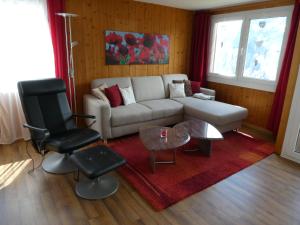 a living room with a couch and a table and chairs at Chalet Gerbera in Wengen