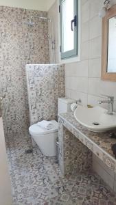 a bathroom with a toilet and a sink at Lefkada Princess Junior Suite in Lefkada Town