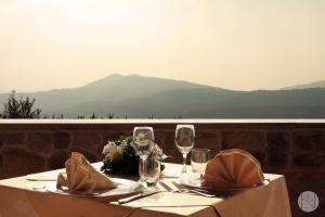 a table with two wine glasses and a table with a view at Locanda Viridarium in Arqua Petrarca